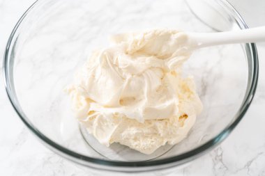 Marketten alınmış tereyağlı kremanın karışımı bardakta karıştırılıyor..