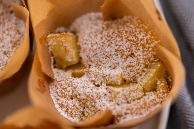 Taze pişmiş elmalı Sharlotka çöreği. Beyaz tabakta pudra şekerle tozlanmış..