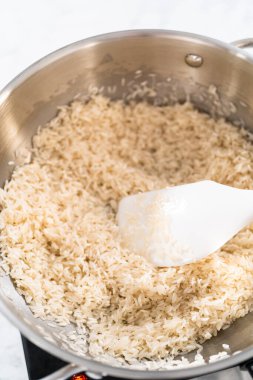 Paslanmaz çelik bir tencerede Meksika pirinci pişirmek.