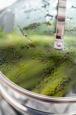 Buharda pişmiş taze kuşkonmaz ve paslanmaz çelik buhar tenceresi..