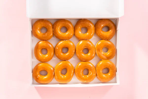 平置きだ 白い紙箱の中に平釉の店売りドーナツ — ストック写真