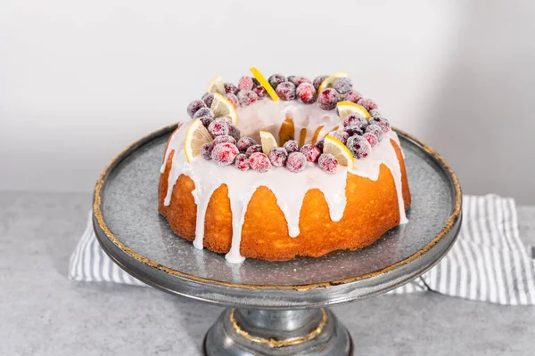 ケーキスタンドには 砂糖クランベリーとレモンウェッジで装飾されたレモンクランベリーバンドケーキ — ストック写真