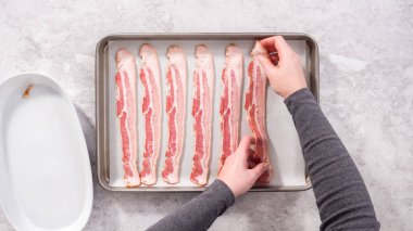 Düz yatıyordu. Adım adım. Pişmemiş pastırma şeritleri ve beyaz parşömen kağıtları..