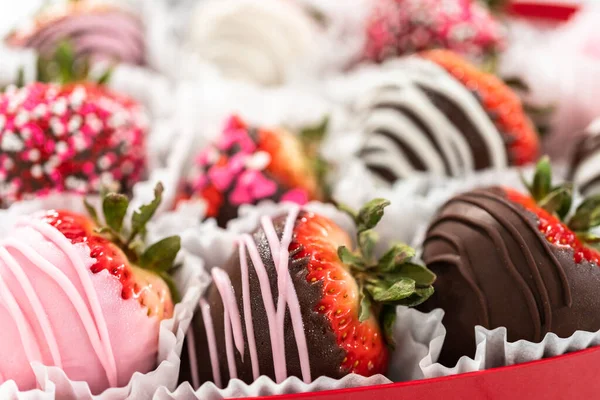 Close up of chocolate covered strawberries with dark, white, and pink chocolate.