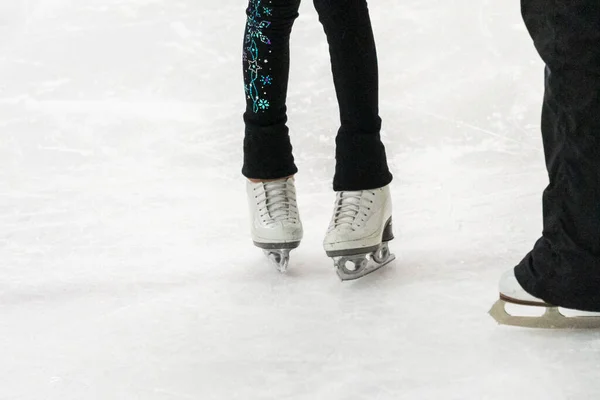 View of a figure skater and her coach feet at the figure skating practice.