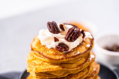 Siyah tabakta bir yığın taze balkabağı gözlemesi.