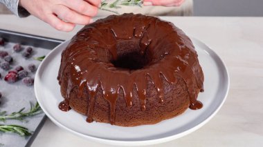 Adım adım. Beyaz pasta standında taze pişmiş çikolatalı kek..