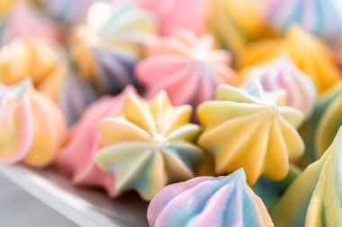 Beyaz servis tabağında çok renkli tek boynuzlu at kurabiyeleri..