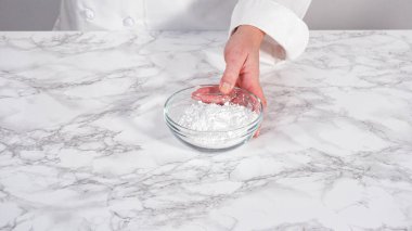 Adım adım. Tek boynuzlu at meringue kurabiyesi yapmak için cam bir kasenin içindeki malzemeler..
