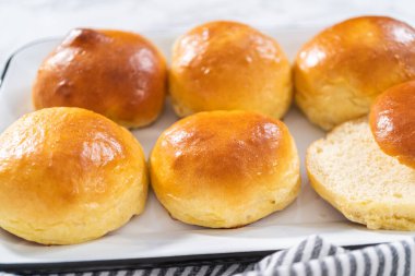 Freshly baked brioche buns on a metal serving tray. clipart