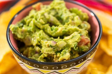 Klasik guacamole sosu küçük bir kasede mısır tortilla cipsi ile.
