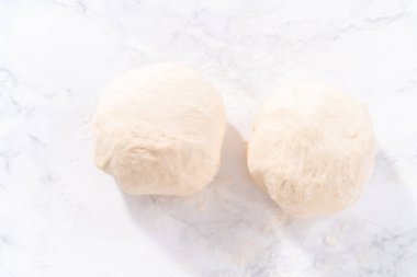 Tarçınlı tatlı pizzası hazırlamak için Fransız merdanesiyle pizza hamuru yuvarlıyorum..