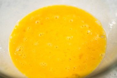 Çikolatalı kurabiyeleri naneli cipsle karıştırmak için büyük bir bardaktaki malzemeleri karıştırıyorum..