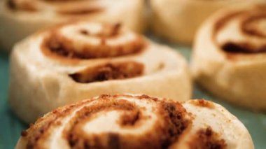 Fırınlanmamış tarçınlı çörekler mavi bir tavada.