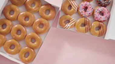 Beyaz bir karton kutuda mağazadan alınmış donutların çeşitliliği.