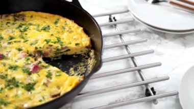 Beyaz bir yemek tabağında ıspanak ve jambonlu omlet yapıyorum..