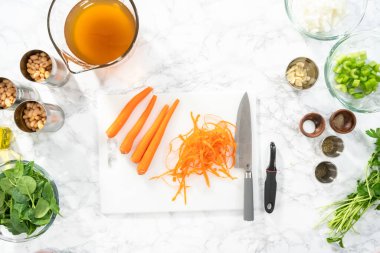 Düz yatıyordu. Beyaz bir kesme tahtasıyla organik havuç kesmek..