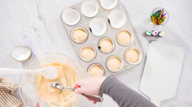 Düz yatıyordu. Adım adım. Vanilyalı Mardi Gras keki pişirmek için kek hamurunu folyoya batırıyorum..