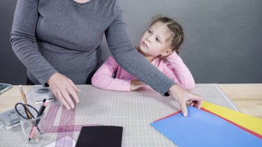 İnşaat kağıdından el yapımı Babalar Günü kartı yapan küçük bir kız..