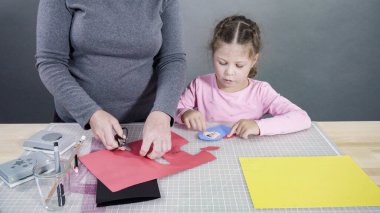 İnşaat kağıdından el yapımı Babalar Günü kartı yapan küçük bir kız..