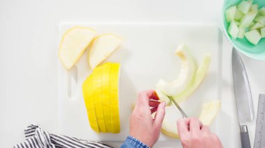 Adım adım. Düz yatıyordu. Beyaz kesme tahtasında kaygan altın çiğ taneli kavun.