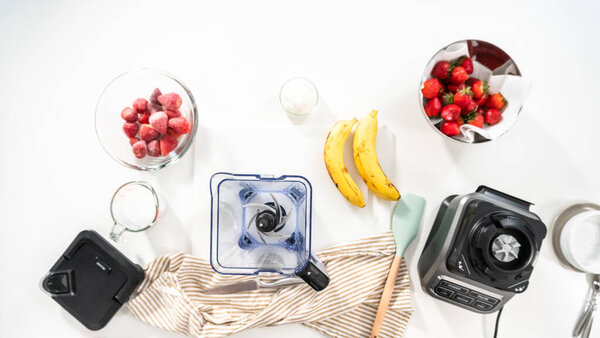 Плоский лежал. Подготовка клубничного бананового коктейля в кухонном блендере.