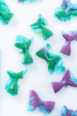 Silikon kalıplardan çikolata deniz kızı kuyrukları çıkarılıyor.