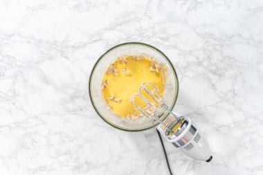 Düz yatıyordu. Malzemeleri karıştırıcı ile karıştırarak büyük bir karıştırma kabında yumurta likörü pişirmek..