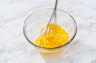 Paskalya pastası pişirmek için kremaya sarı gıda boyası karıştırıyorum..