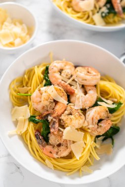 Beyaz seramik kaselerde ıspanaklı sarımsaklı karides makarnası servis ediyorum..