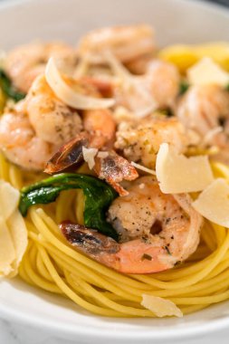 Beyaz seramik kaselerde ıspanaklı sarımsaklı karides makarnası servis ediyorum..