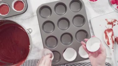 Making Red velvet cupcakes with cream cheese frosting and decorates with heart and kiss shaped red chocolates