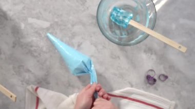 Tek boynuzlu at kurabiyesi pişirmek için besin boyasını kremaya karıştırıyorum..