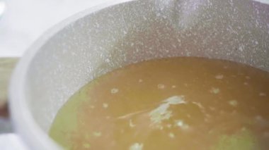 Küçük elektrikli ocağın üzerinde küçük bir tencerede karamelize şeker.