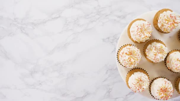 イタリアのバタークリームとケーキスタンドにスプリンクルを持つカボチャのスパイスカップケーキ — ストック動画