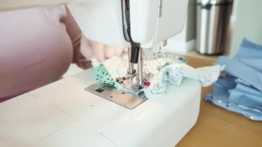 Koronavirüs salgını için dikiş makinesiyle pamuk yüz maskesi dikiyorum..