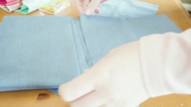 Koronavirüs salgını için dikiş makinesiyle pamuk yüz maskesi dikiyorum..