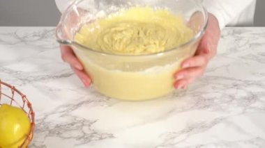 Mixing ingredients in kitchen to make lemon buttercream frosting for lemon cake