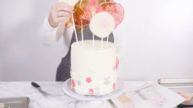 Süslenmek için uzun beyaz yuvarlak pastanın içine kar taneli büyük lolipoplar yerleştiriyoruz..