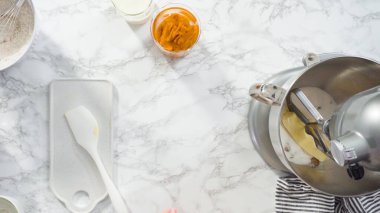 Düz yatıyordu. Kabak aromalı kek pişirmek için elektrikli mutfak mikserinin malzemelerini karıştırıyorum..