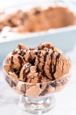 Ev yapımı çikolata parçalı dondurmayı cam bir kasede çikolatayla servis ediyorum..