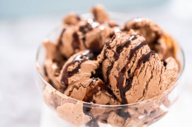 Ev yapımı çikolata parçalı dondurmayı cam bir kasede çikolatayla servis ediyorum..