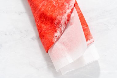 Yuvarlanan kırmızı ve mavi ekmek hamuru vatansever tarçın kıvrımları pişirmek için.