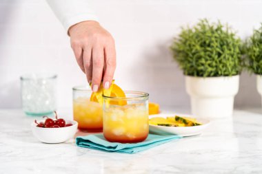 Adım adım. Bir dilim taze portakal ve ananasla süslenmiş dekore edilmemiş kokteyl..