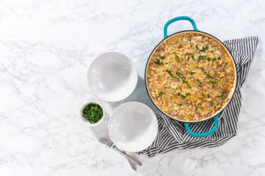 Düz yatıyordu. Beyaz seramik kaselerde ev yapımı hamburger servisi..