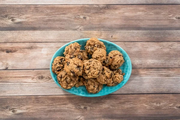 Flat lay. Freshly baked chewy oatmeal raisin cookies on a blue plate.