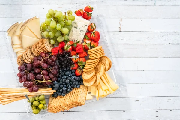 Düz yatıyordu. Meyveli, peynirli ve krakerli gurme peynir tabağı..