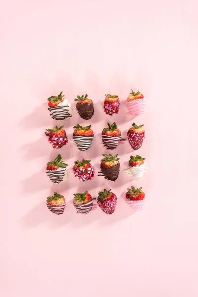 平躺在床上粉红背景的巧克力蘸草莓的品种 — 图库照片