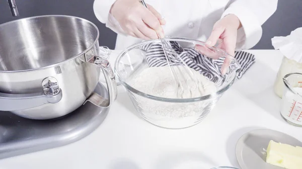 Mixing ingredients in a kitchen standing mixer to bake cinnamon rolls.