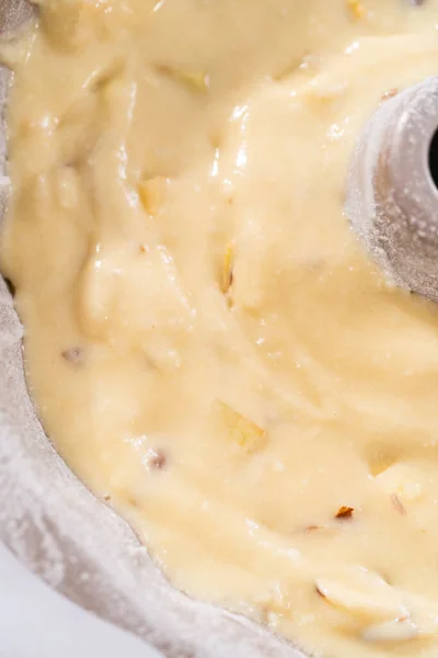 Cake batter in a bundt cake pan to bake apple bundt cake with caramel glaze.